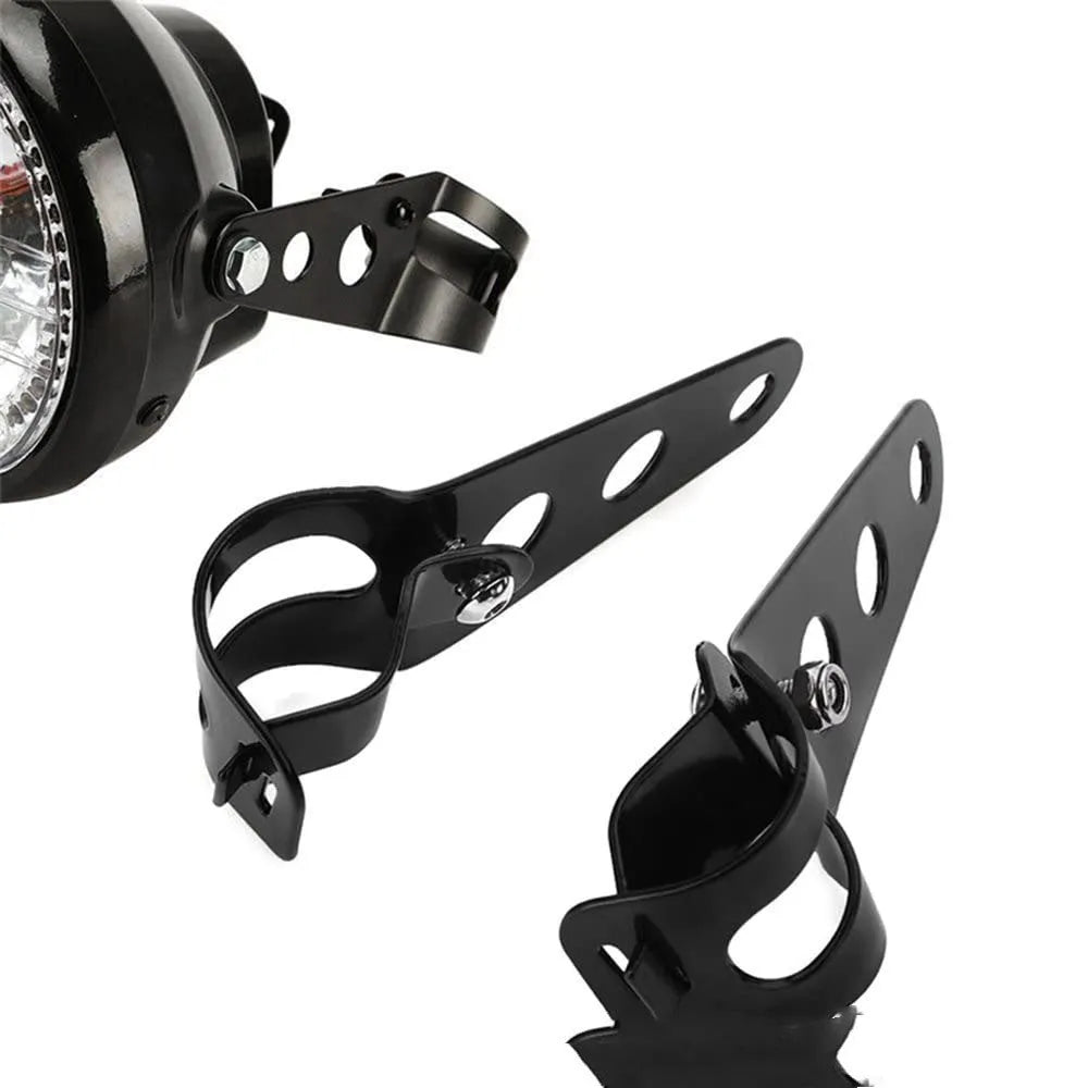 A pair of black iron motorcycle headlamp support brackets for retro modification.