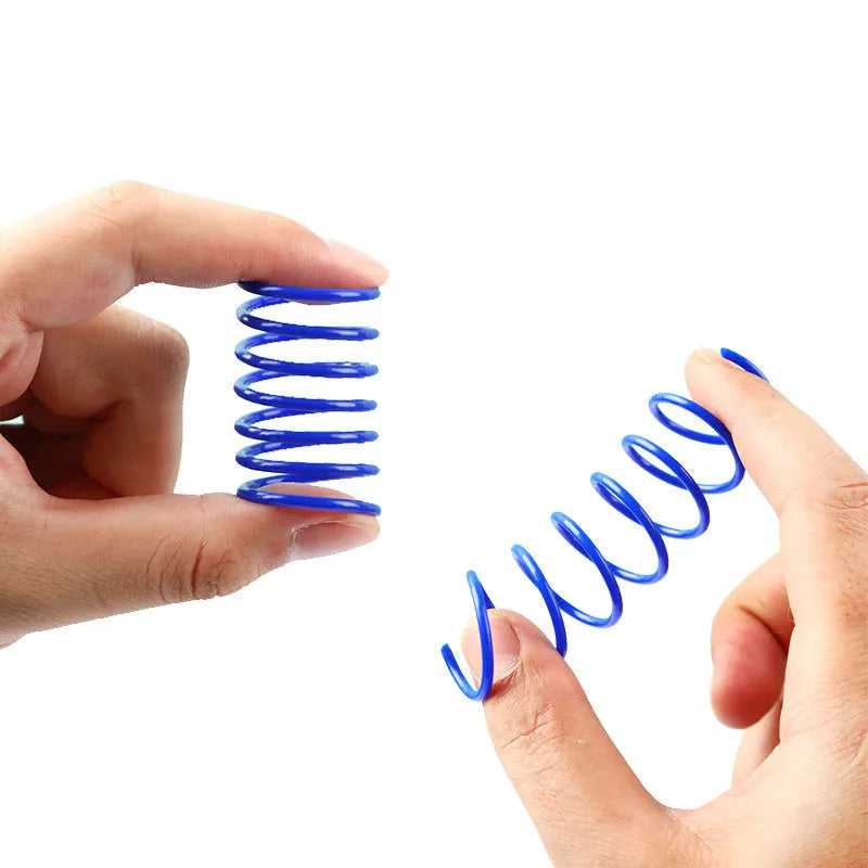 Colourful plastic coil spring cat toys shown in a mixed group, each measuring 5.5 cm long.