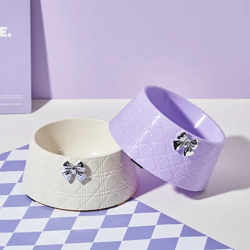 Decorative pet bowl with bowknot and diamond pattern in pink, silver, black, purple, and white colours.