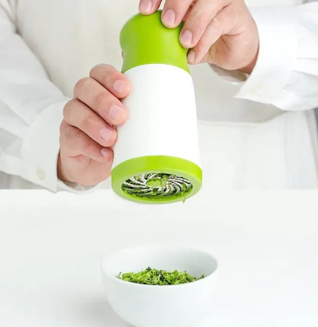 White and grey manual herb grinder with a removable top, showing stainless steel blades inside.