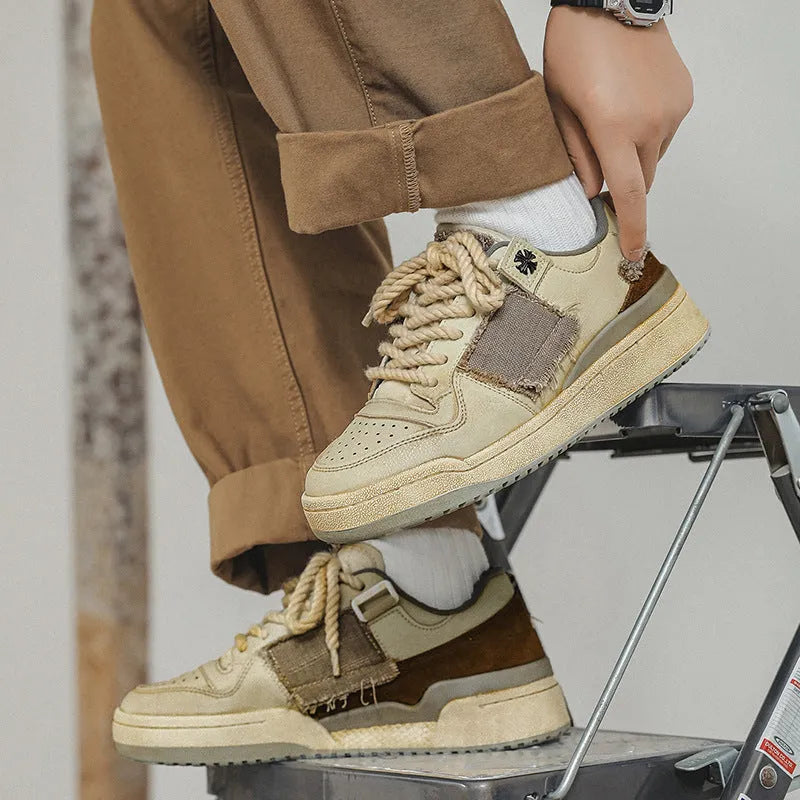 Beige low-top skateboard shoes with microfiber uppers, round toe, and lace-up closure on solid background