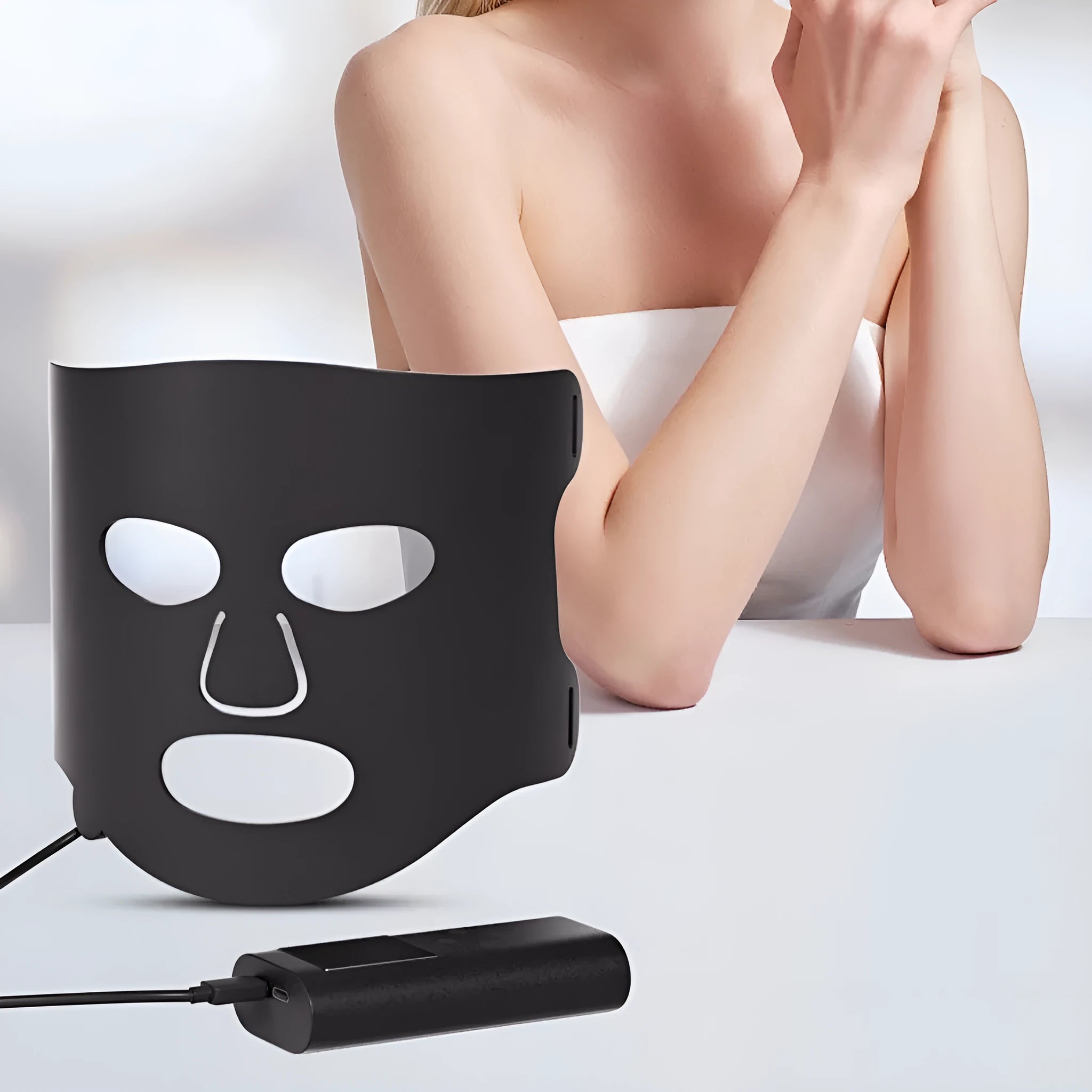 Black and gold LED phototherapy face mask with controller on a white background.