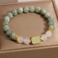 Natural oil green emerald crystal bracelet with five beads on a black elastic cord.