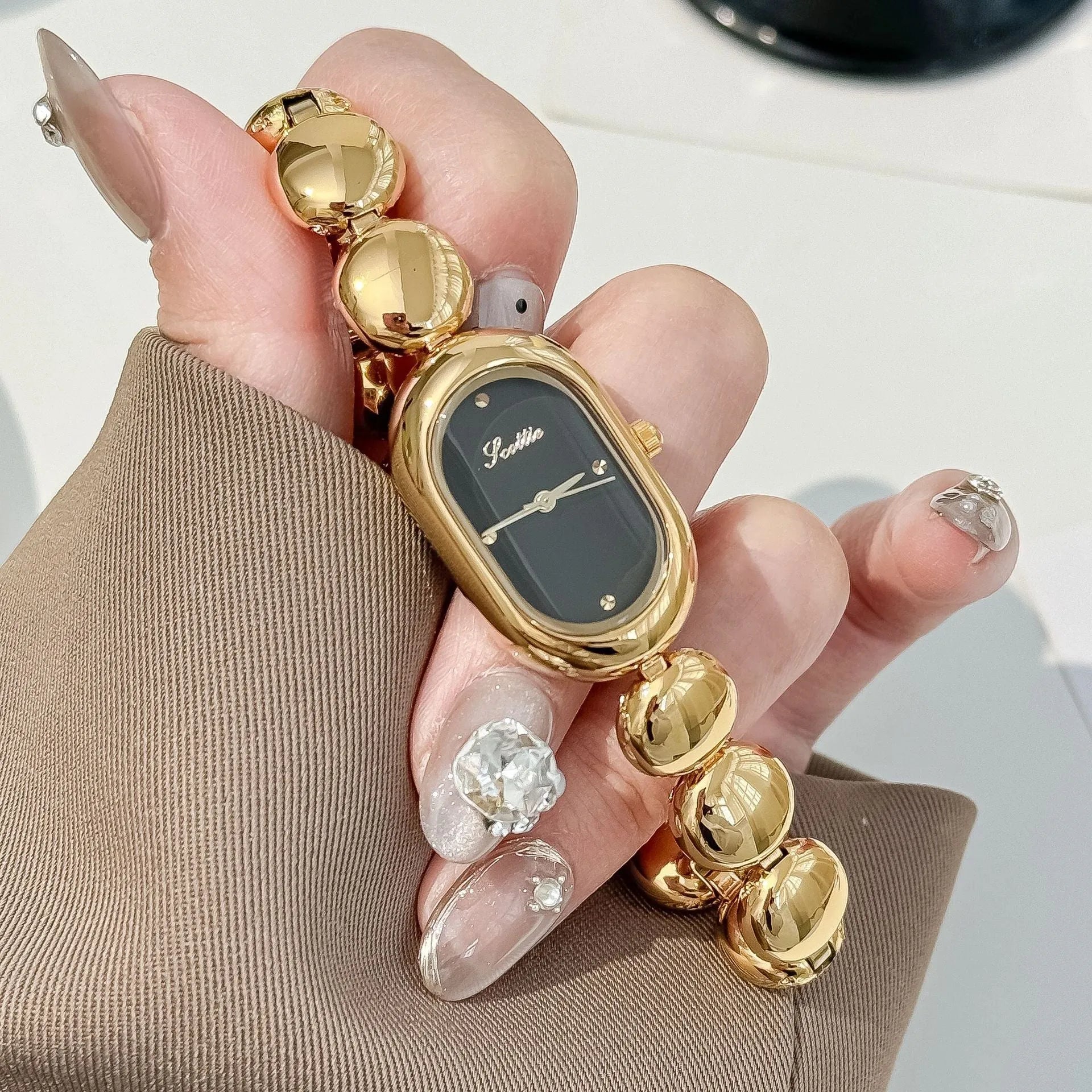 Women's oval fashion watch in black gold colour with 9mm thickness case