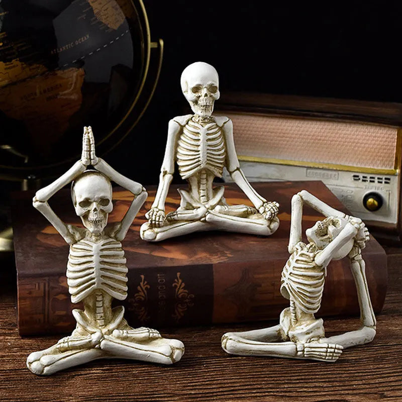 Hand-painted resin yoga pose skull skeleton ornament measuring 10.5-11cm wide on wooden desktop