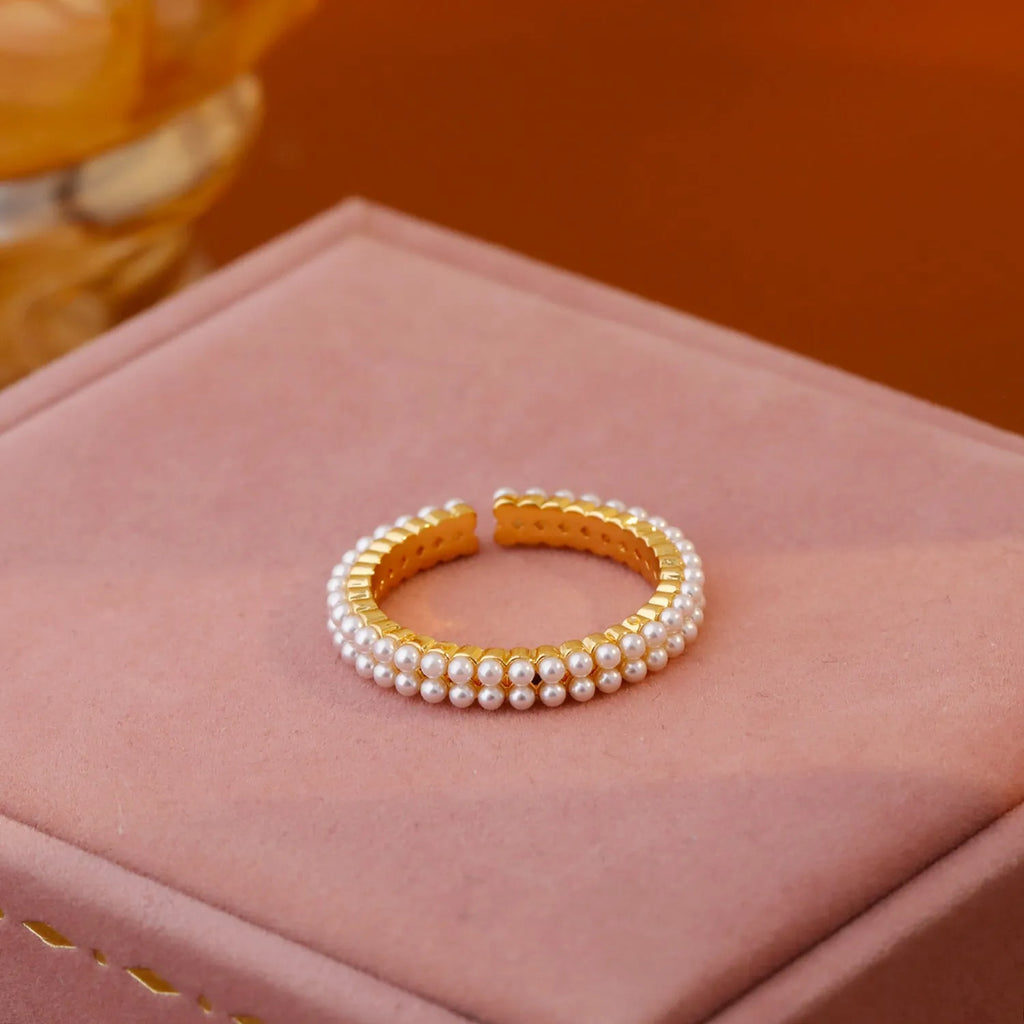 Gold-coloured geometric open-mouth ring with pearl detailing on copper electroplated band