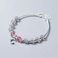 Handmade silver-tone adjustable bracelet with a moonstone bead and small crescent moon charm on a white background.
