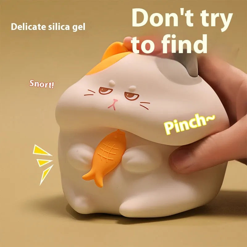 Small yellow Greedy Cat cartoon desktop night light with socket plug on desk.