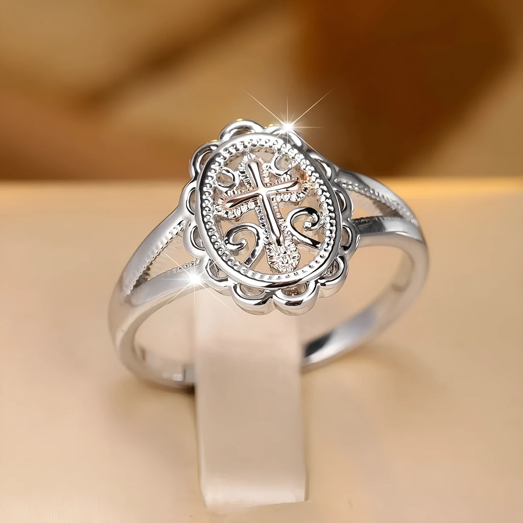 Silver coloured women's ring with a detailed cross charm featuring a lace pattern.