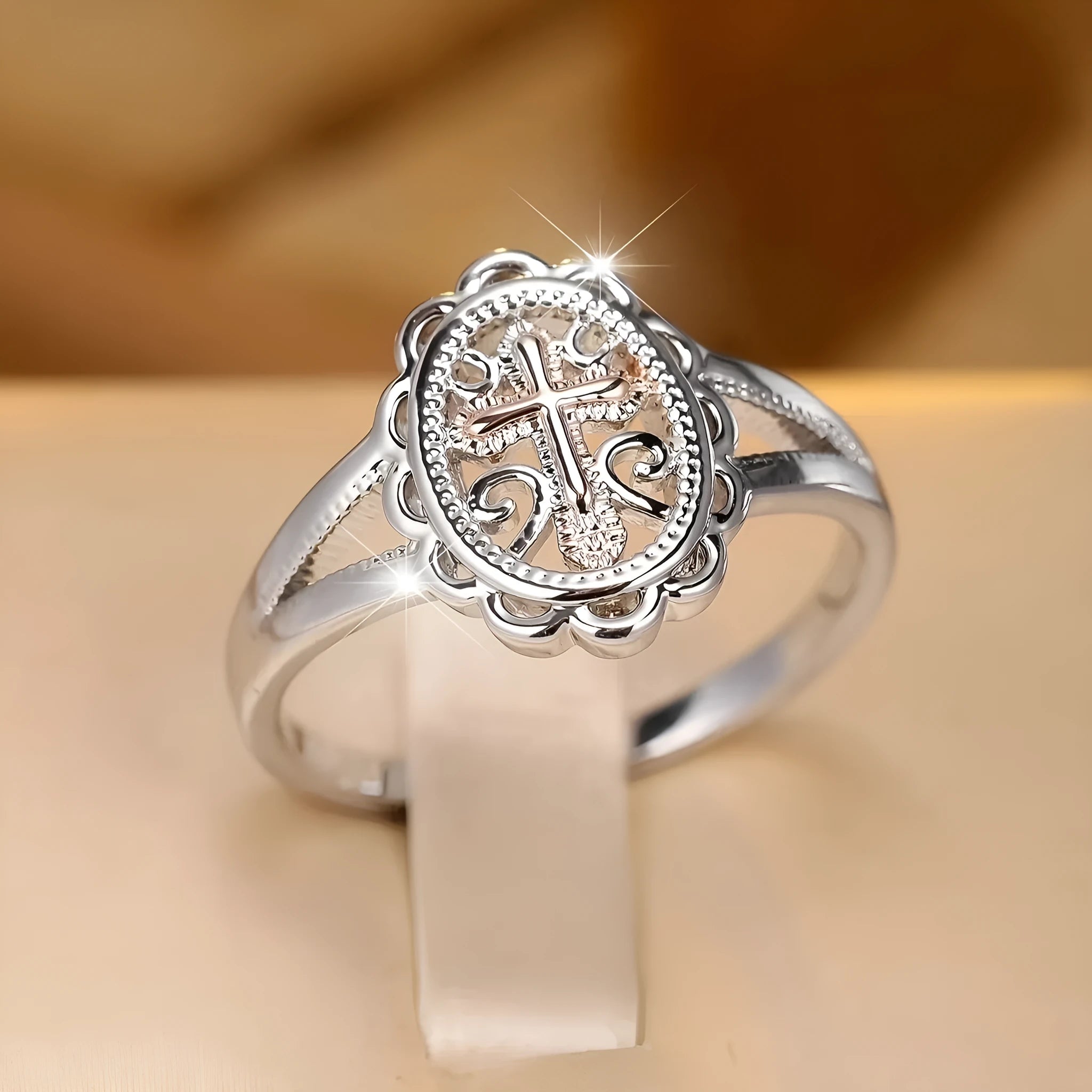 Silver coloured women's ring with a detailed cross charm featuring a lace pattern.