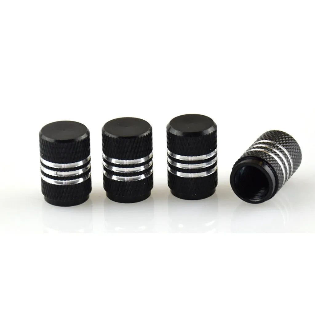 Set of coloured aluminium alloy car tyre valve caps with stainless steel cores on a grey background.
