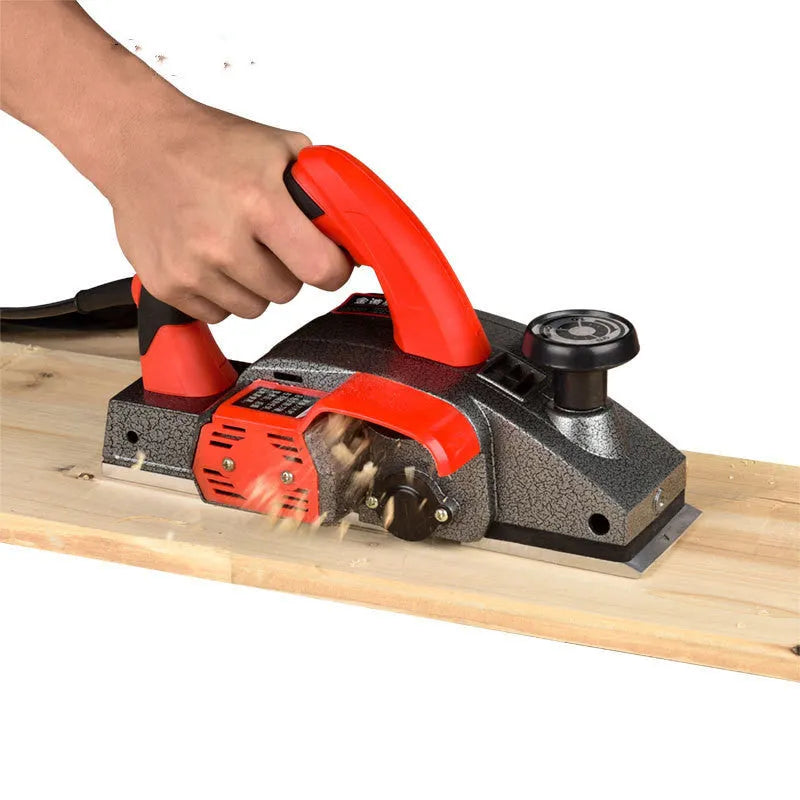 Red electric push planer with aluminium body, 82mm planing width, for woodworking tasks