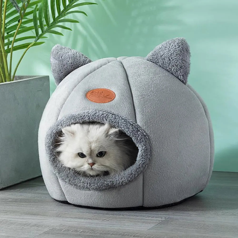 Large fully enclosed fabric cat house with a single entrance, shown in a home setting.