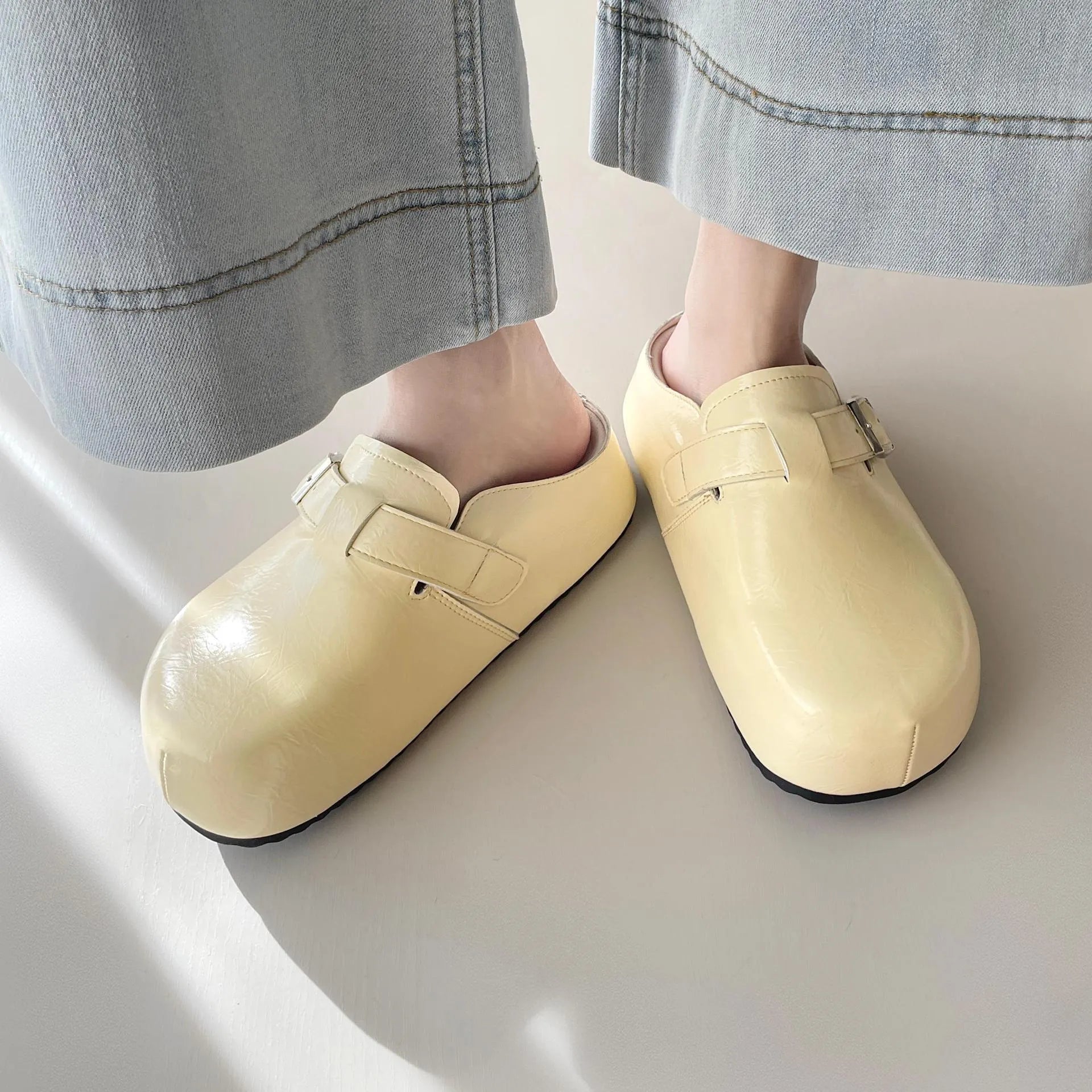Flat buckle casual sneakers in yellow, creamy-white, silver, and black colours, showing round toe and PU upper.