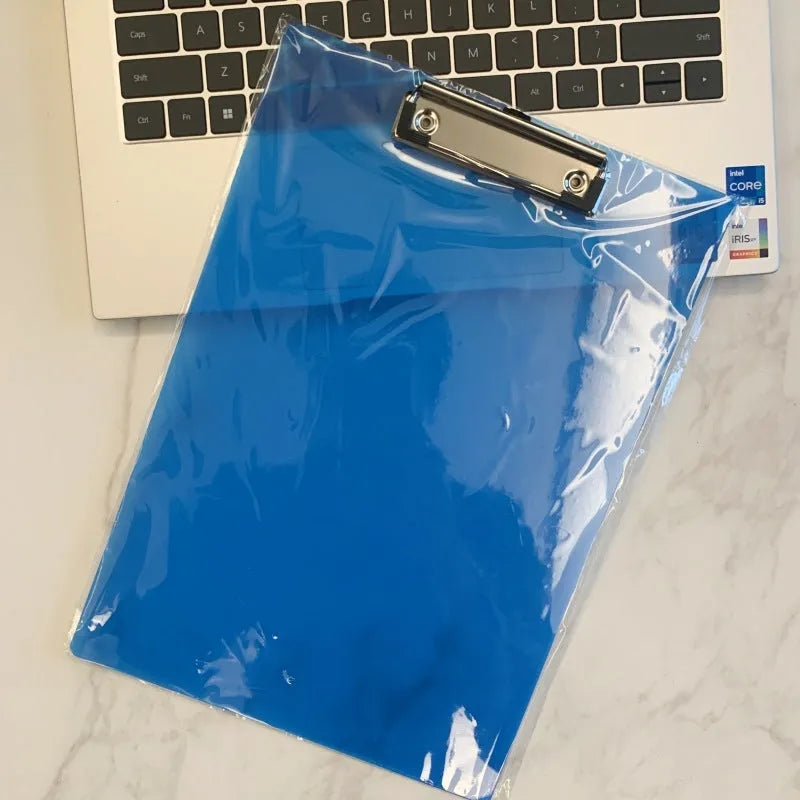 Clear A4 plate holder with metal clip and transparent writing pad in blue colour on a desk.