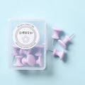 Box of plastic push pins in mint green, pink, and lavender colours, showing large and small thumbtacks for bulletin boards.