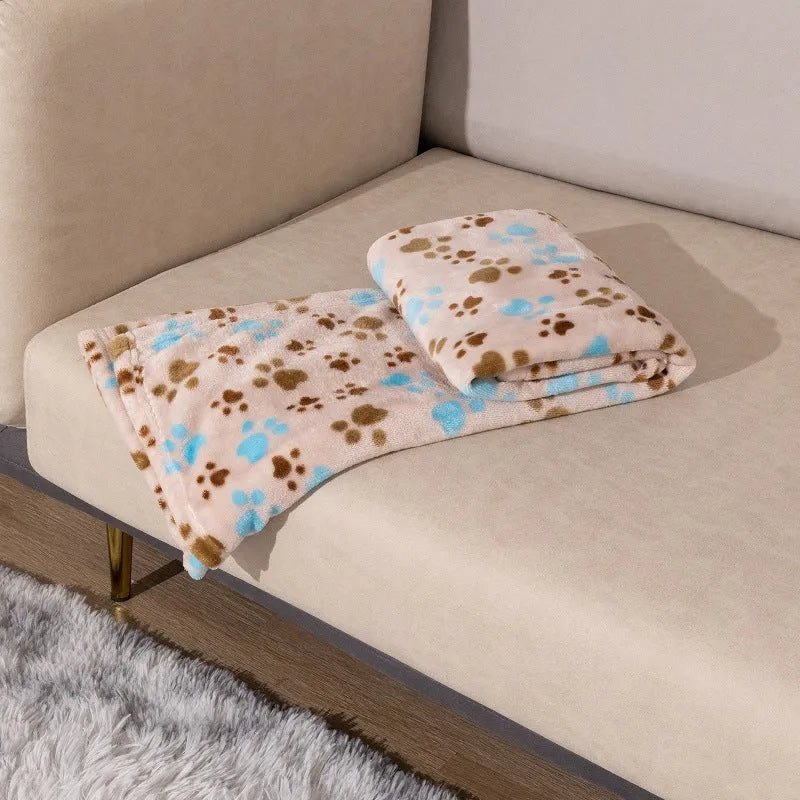 Double-sided dog blanket with cartoon patterns in blue dog, khaki paw, and blue paw designs on polyester flannel