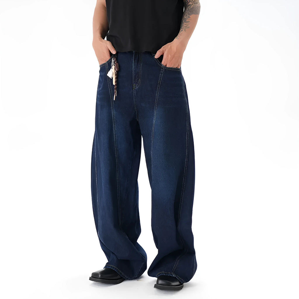 Dark blue wide leg jeans with a distressed wash and machete cut, laid flat.