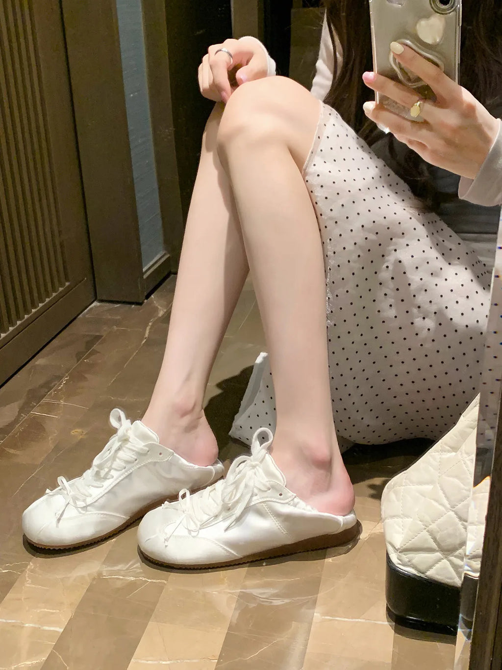 Women's silver grey satin ballet flat with front lace-up fastening and a round toe, shown on a white background.