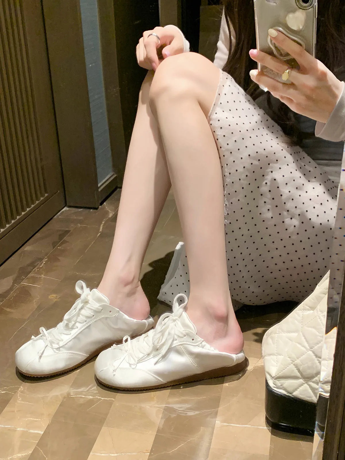 Women's silver grey satin ballet flat with front lace-up fastening and a round toe, shown on a white background.