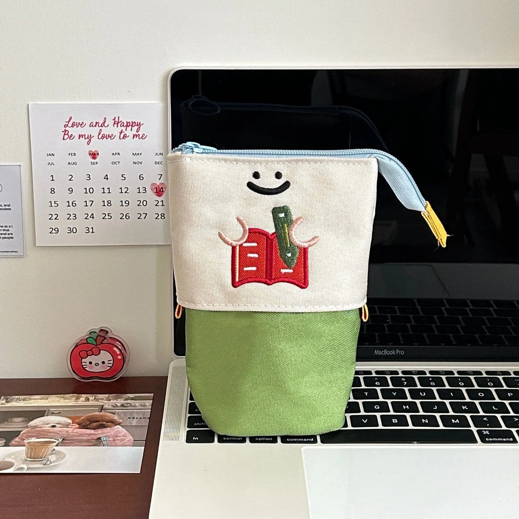Brown collapsible pencil case with Korean-style cartoon design showing 17x14cm dimensions and Oxford fabric texture