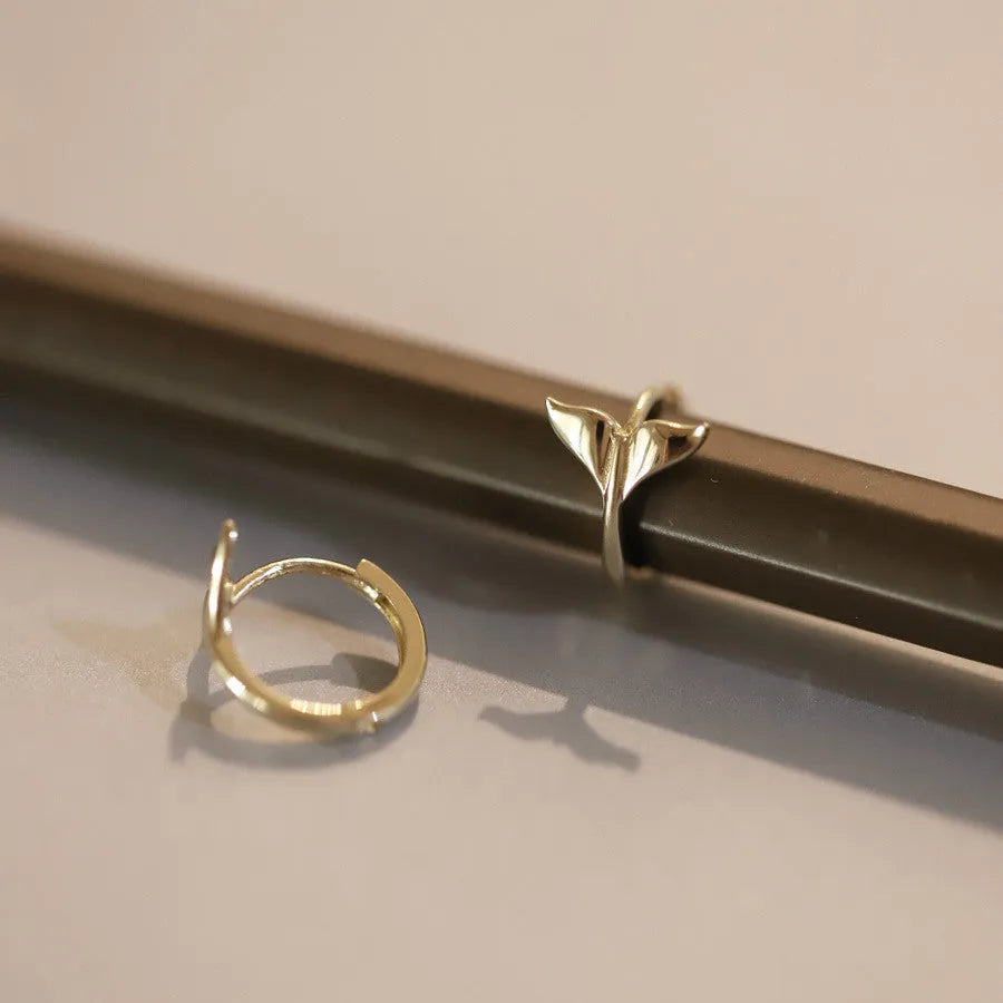 Pair of smooth fishtail earrings in gold or white gold plating, made from 925 sterling silver, showing simple design.