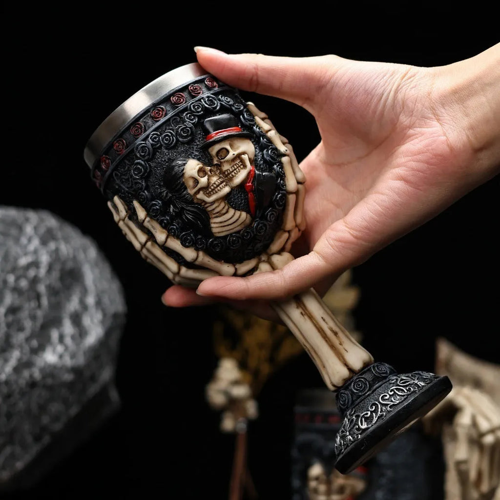 Two stainless steel red wine glasses with a detailed skeleton design, shown as a couple's set.