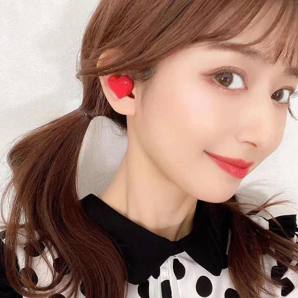 Heart-shaped wireless Bluetooth headphones in red or pink colour with charging cable