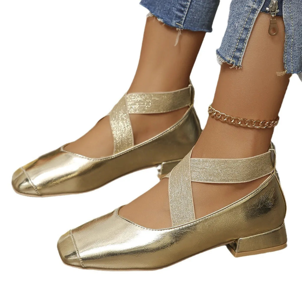 Gold slip-on evening pump with square toe and low rubber heel on a white background