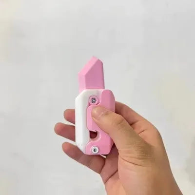 3D printed orange and green carrot-shaped gravity flick knife fidget toy on a white background.