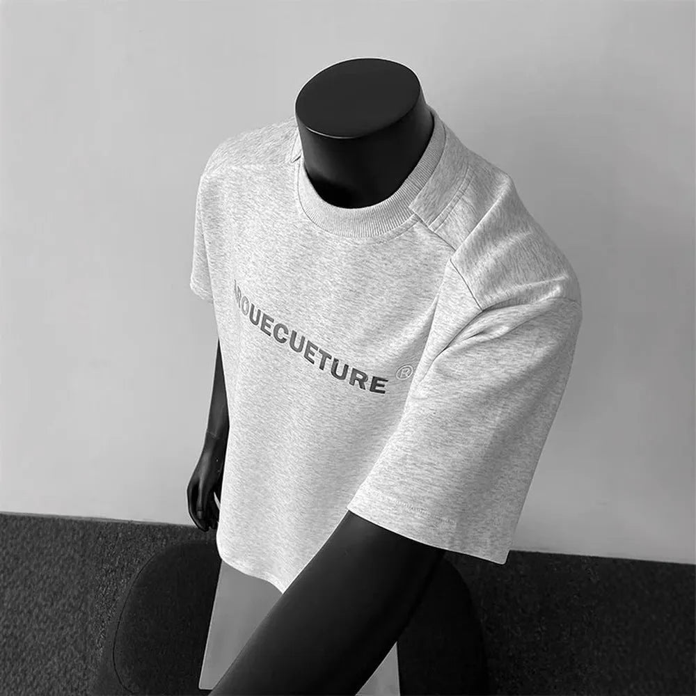 Men's short-sleeve cotton pullover in light grey with letter pattern, showing loose fit and regular sleeves.