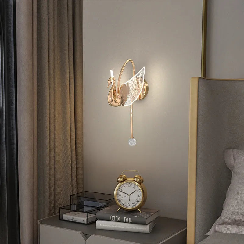 Gold swan-shaped wall lamp with acrylic shade and iron body, mounted beside bed with adjustable LED lighting