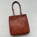 Brown woven leather tote bag with three-dimensional pocket, showing 27x30x6cm dimensions and handmade construction
