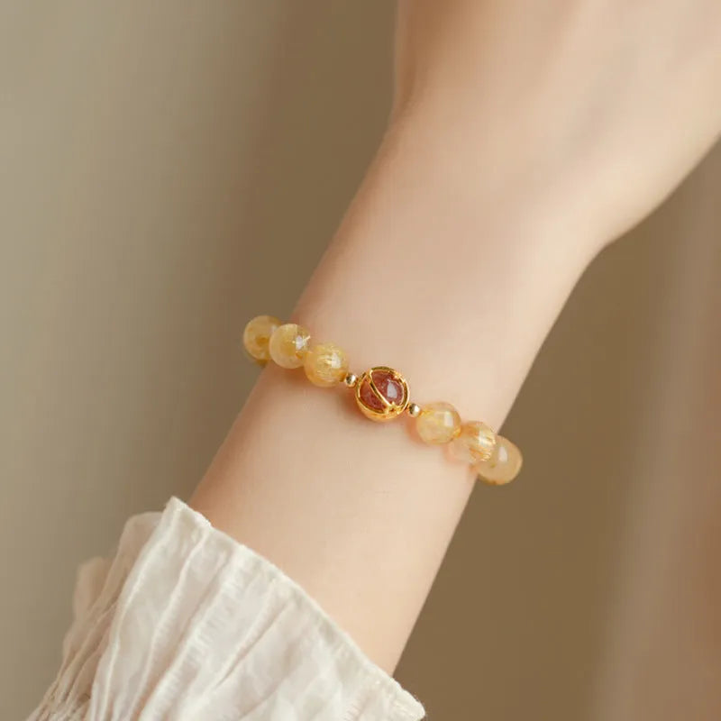 Gold rutilated quartz crystal bracelet with diamond-cut beads on stretch cord in Korean style