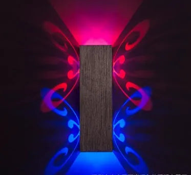 Aluminium butterfly-shaped LED wall lamp in blue, mounted on a white wall.