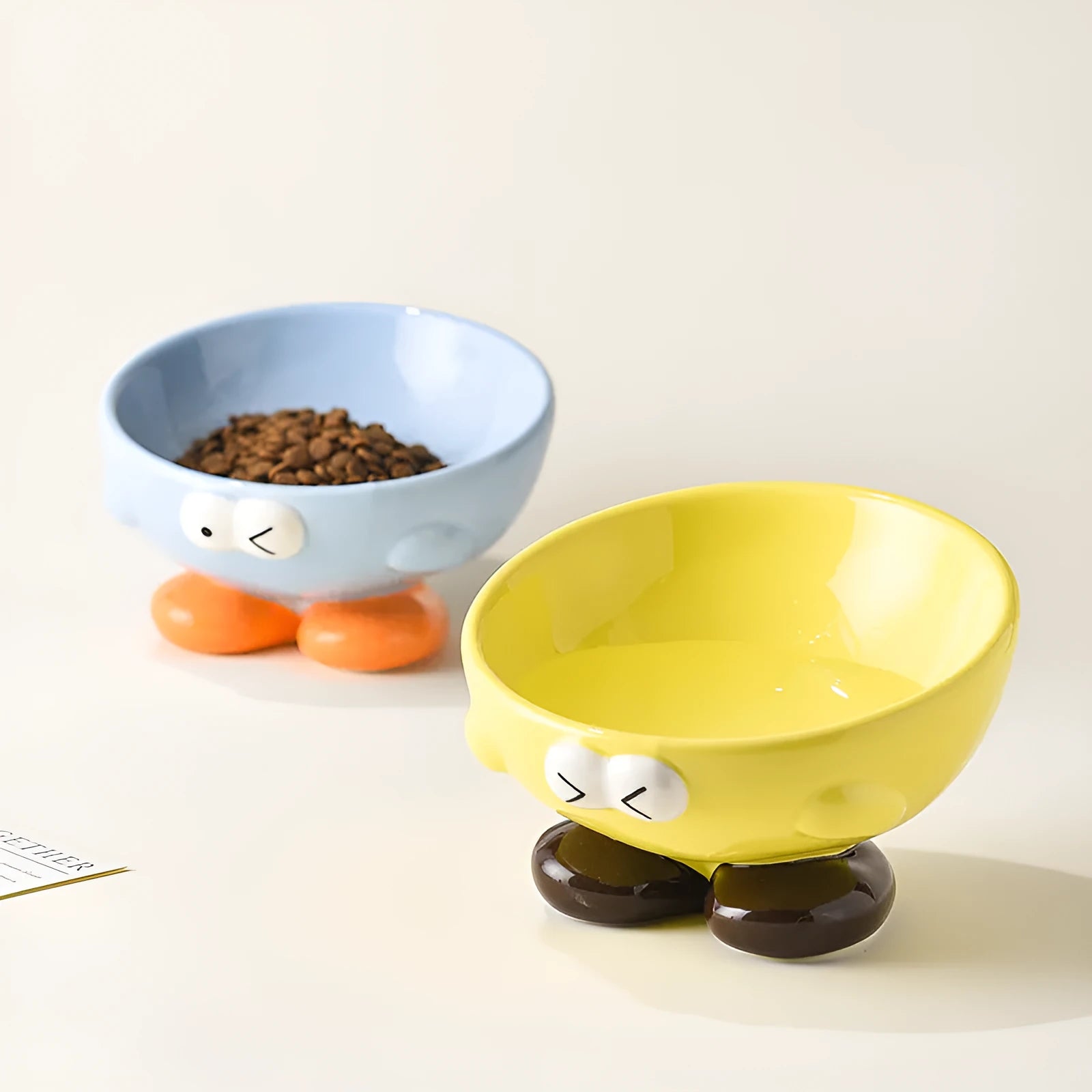 Blue slanted ceramic pet bowl for cats and dogs on a plain background.