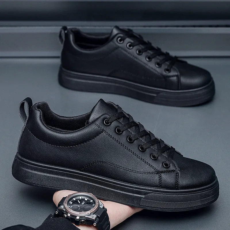 Men's low-top casual sneakers in black with white sole, showing round toe and flat heel design.