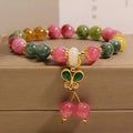 Colourful tourmaline butterfly pendant bracelet with rhinestone details on a woman's wrist.