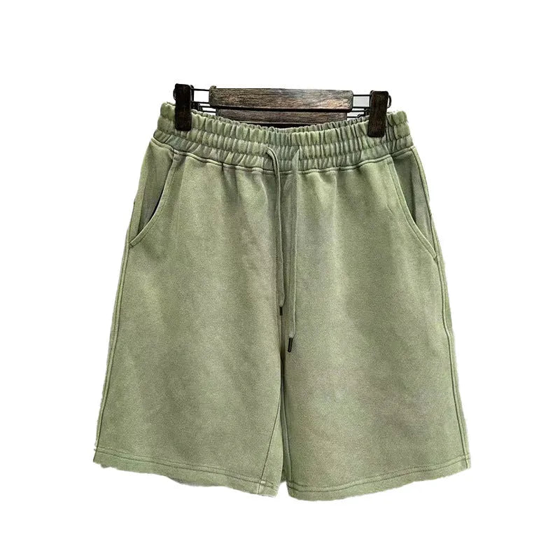 Man wearing navy blue distressed cotton casual shorts with a loose, straight-leg fit.