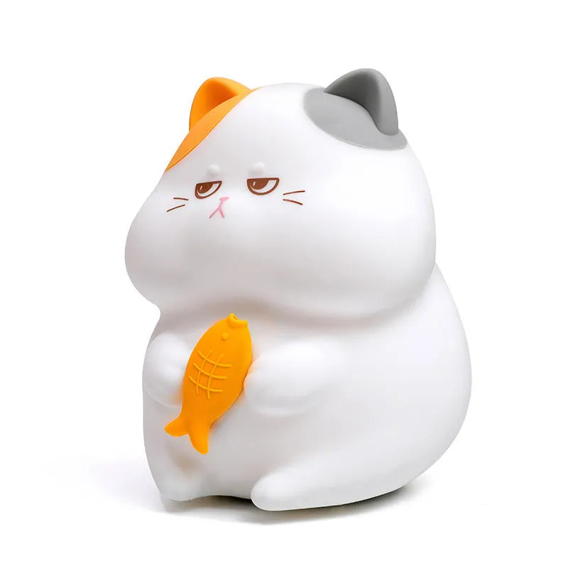 Small yellow Greedy Cat cartoon desktop night light with socket plug on desk.