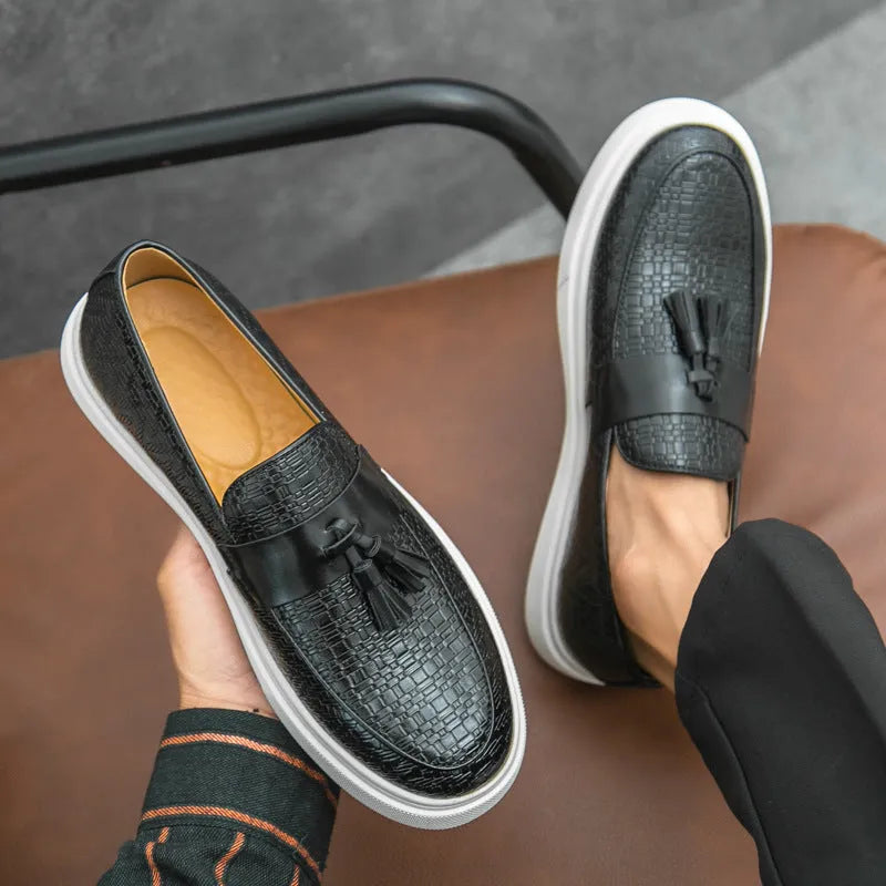 Men's black casual leather shoes with fringe detail on the upper and a low heel.