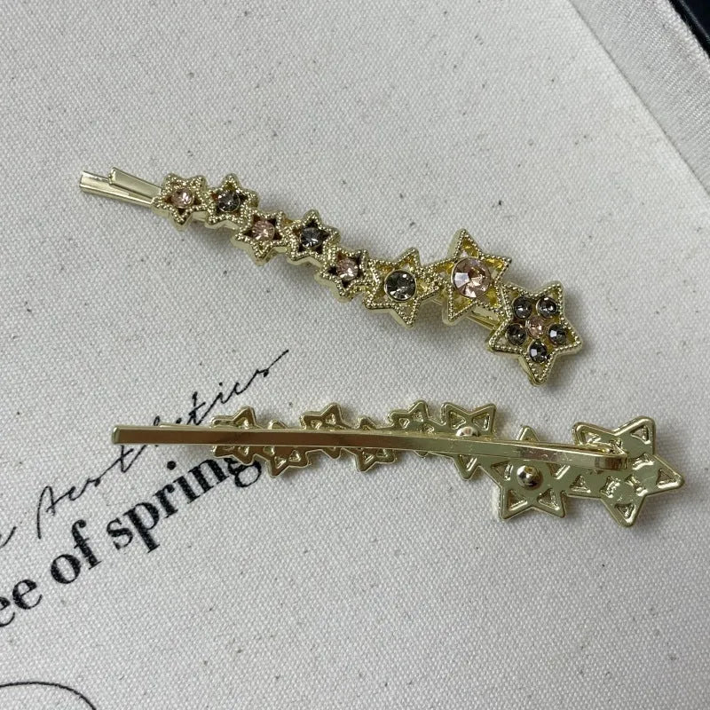 Gold metal hair barrette with a star charm and side clip for bangs.