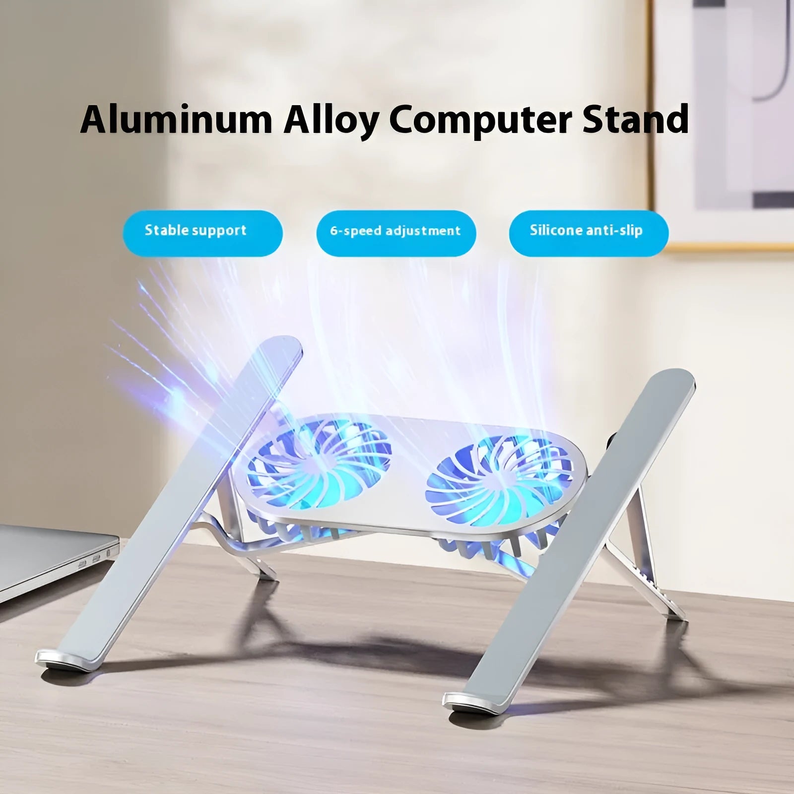Silver aluminium laptop stand with twin cooling fans in folded position beside laptop