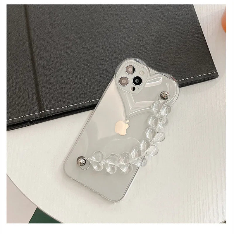 Transparent iPhone case with a soft TPU build and an integrated love heart chain, shown on a phone.