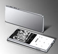 Black portable MP3 player with 2.4-inch touch screen showing music playlist, placed on a desk