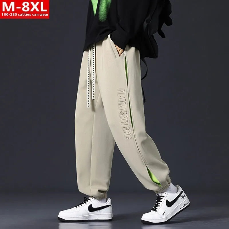 Men's ankle banded trousers in micro-elastic cotton with collage stitching, showing skinny leg and mid-waist fit.