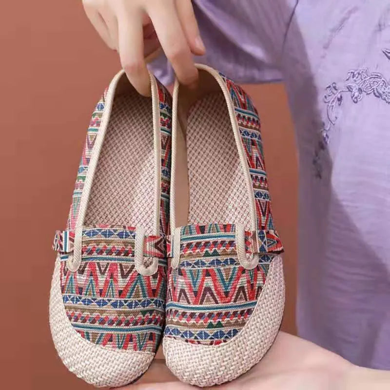 Women's ethnic style cloth shoes with flat heel, colour stitching, and a shallow mouth design.