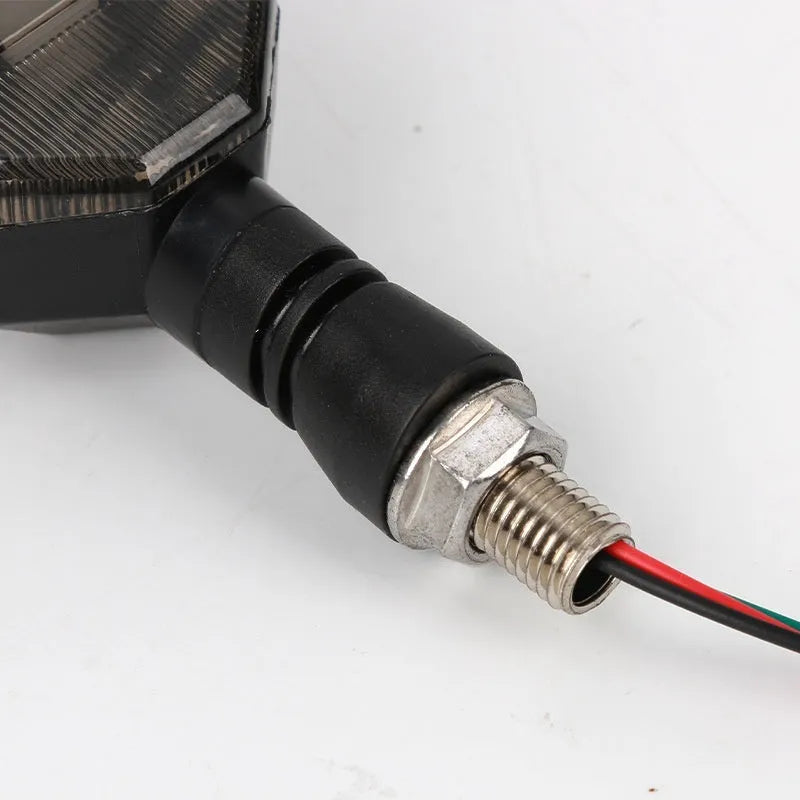 Arrow-shaped LED motorcycle turn signal lamp for 12V systems, made from black ABS plastic.