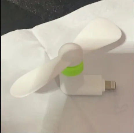 White portable mini fan with plastic blades and a rotary switch for mobile phones.