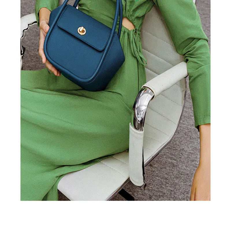 Leather tote cross-body wing bag in soft cow leather with latch closure and wing shape design.